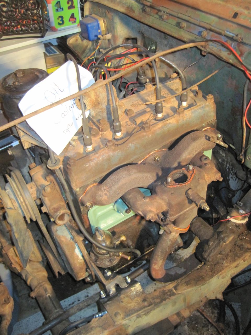 Engine compartment with a paper note that says "Oil Coolant"