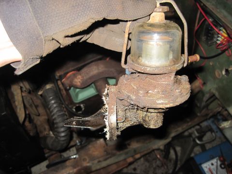 1946 Jeep Willys - Rusty fuel pump assembly with glass bowl, likely removed from an older vehicle's engine bay.