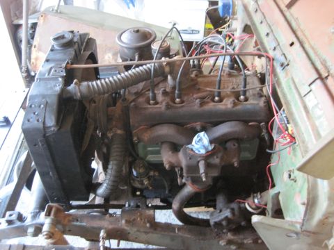 1946 Jeep Willys - The engine bay of a vehicle, showing the radiator and an inline-six engine with various hoses and wiring.