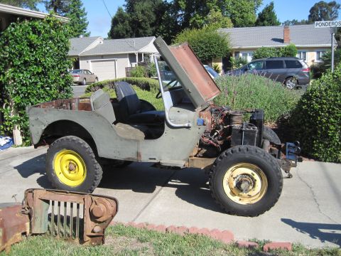 1946 Jeep Willys - This 1946 Jeep CJ5 is shown with its hood open, revealing the engine compartment and a detached grille in the foreground.