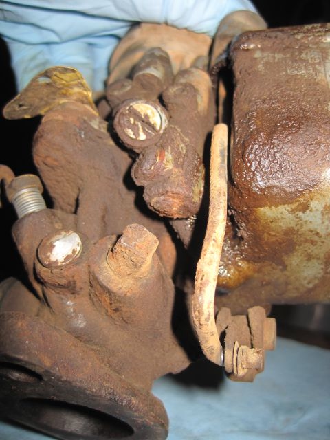 1946 Jeep Willys - Close-up of heavily rusted automotive parts, including a carburetor and brake cylinder, with a Supermotors.net watermark visible.