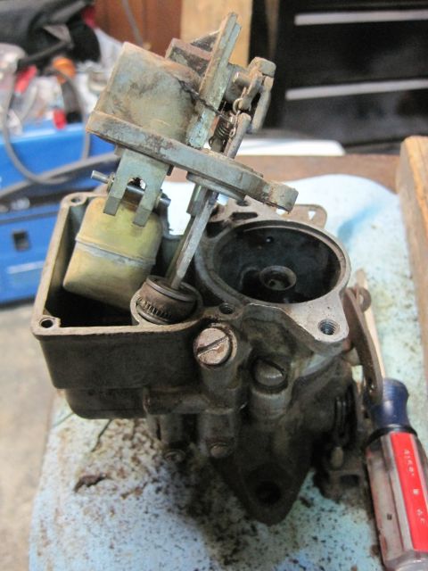 1946 Jeep Willys - A close-up view of a carburetor, a critical engine component, is shown on a workbench.