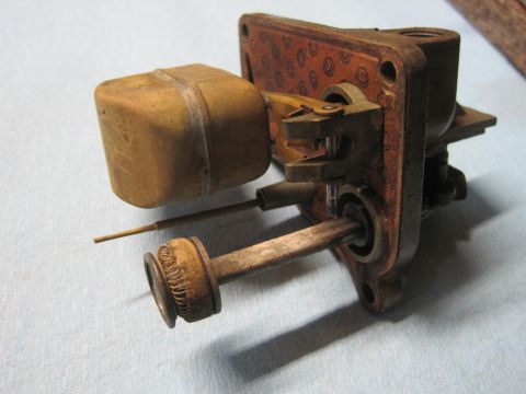 1946 Jeep Willys - Close-up of a carburetor float bowl assembly, showing the brass float and associated mechanical components.