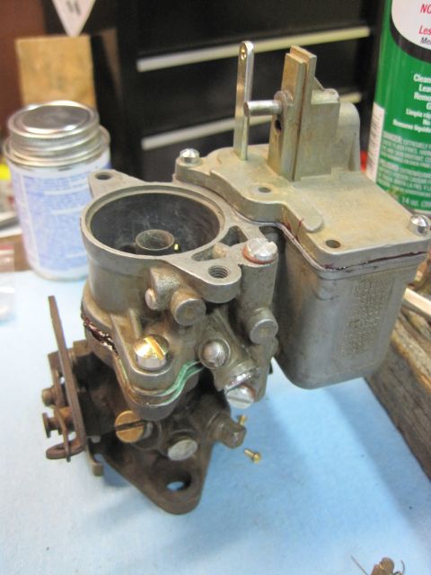 1946 Jeep Willys - Carburetor part shown on a workbench with a can and jar in the background.