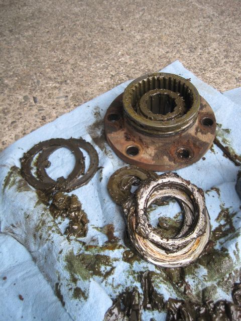 1946 Jeep Willys - Several greasy Jeep drivetrain components are laid out on a blue shop towel on a concrete surface.
