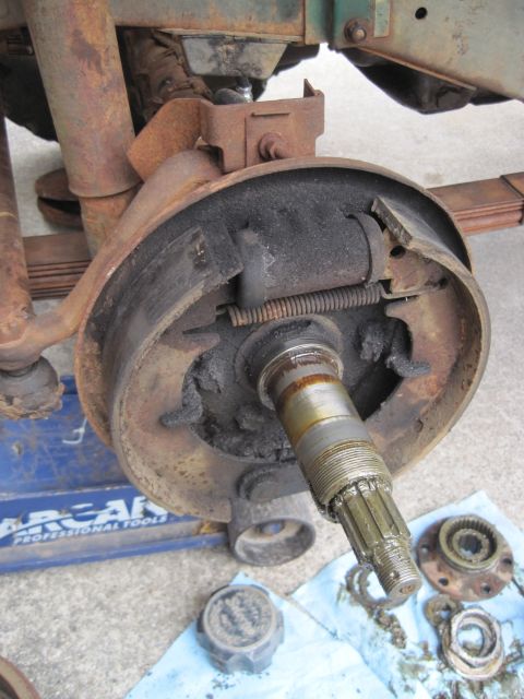1946 Jeep Willys - Close-up of a heavily corroded Jeep front axle brake drum assembly, indicating significant wear and tear.