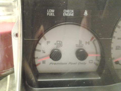 2004 Ford Crown Victoria - The fuel gauge shows low fuel, and the check engine light is on.