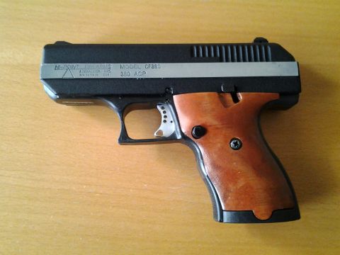 2003 Ford Crown Victoria - A Hi-Point Firearms Model CF380 pistol chambered in 380 ACP rests on a wooden surface.
