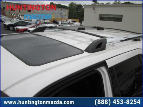 2009 Ford Expedition - A white SUV's roof is visible, a sunroof and roof rack, with other cars in the background.