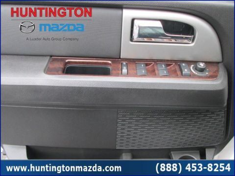 2009 Ford Expedition - Close-up of a car's interior door panel, wood grain trim and power controls.