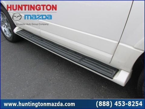 2009 Ford Expedition - Side view of a white SUV black running boards. The image also displays the Huntington Mazda logo and website address.