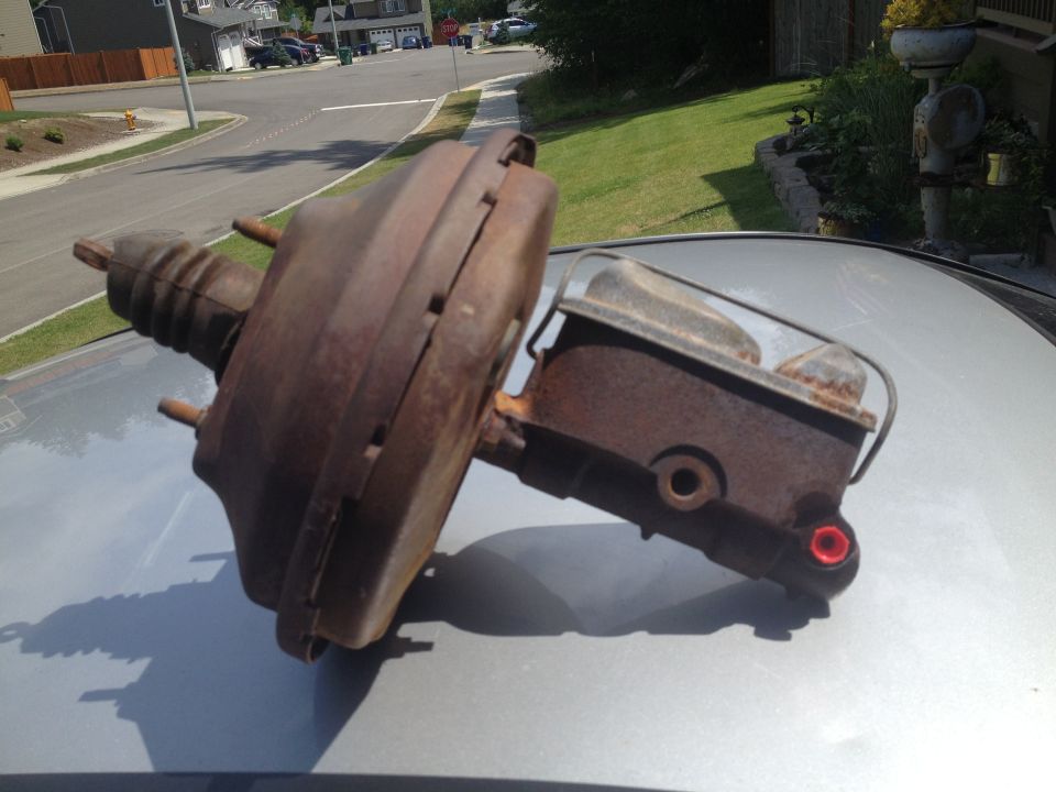 Rusty brake booster and master cylinder assembly on a car's hood