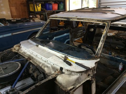 1964 Ford Fairlane - A 1964 Ford Fairlane is shown in a state of deconstruction, with its interior and engine bay exposed.