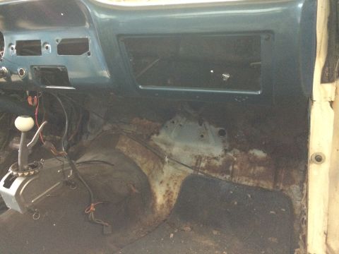 1964 Ford Fairlane - Interior view of a car's dashboard and floor, showing significant rust and an automatic shifter.