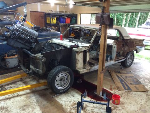 1964 Ford Fairlane - A 1964 Ford Fairlane is shown in a garage, with its engine hoisted out for deconstruction or repair.