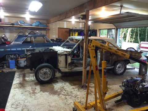 1964 Ford Fairlane - A blue 1963 Ford Galaxie 500 coupe is in a state of disassembly, with a white convertible visible behind it in the garage.