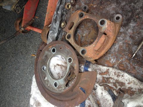 1978 Ford Bronco - Disassembled and heavily rusted brake components are laid out on a cloth.