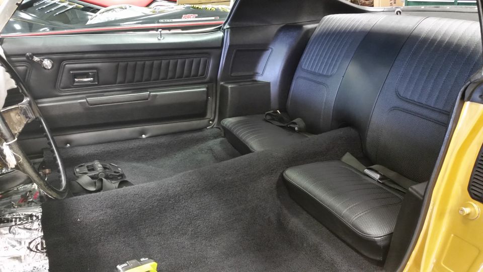 1970 Chevrolet Camaro interior showing black carpet, front and rear seats, and door panels