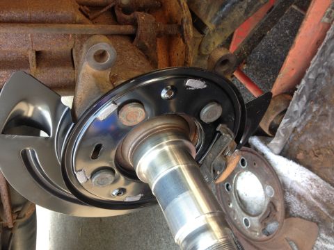 1978 Ford Bronco - Close-up of a vehicle's rear axle assembly, showing a new brake rotor and dust shield.