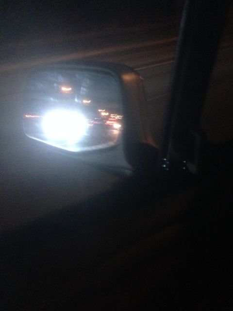 1992 Ford F-150 - Traffic lights and headlights reflected in the side mirror during a night drive.