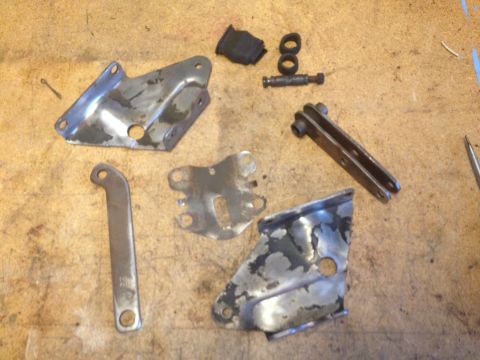 1978 Ford Bronco - Various metal brake components and rubber pieces are laid out on a wooden surface.