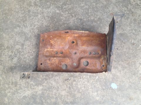 1978 Ford Bronco - This heavily rusted metal bracket has stamped markings and appears to be a vehicle part.