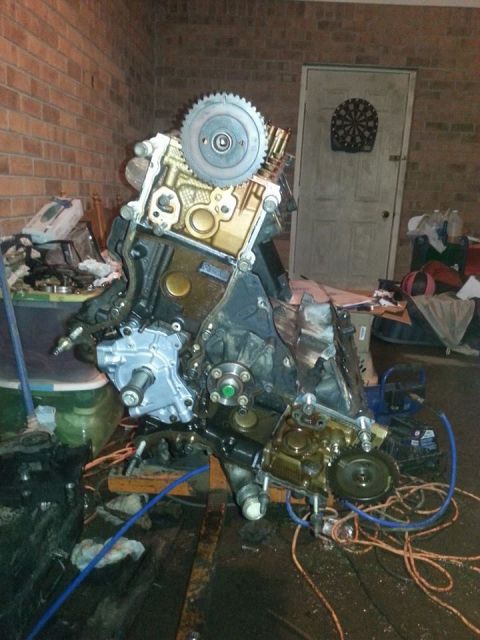 2002 Ford Expedition - Engine assembly shown in a garage setting with various tools and containers around.