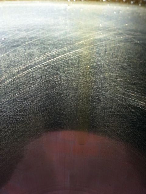 2002 Ford Expedition - A close-up view of a heavily scratched metal surface, possibly a car part, with a website logo visible.