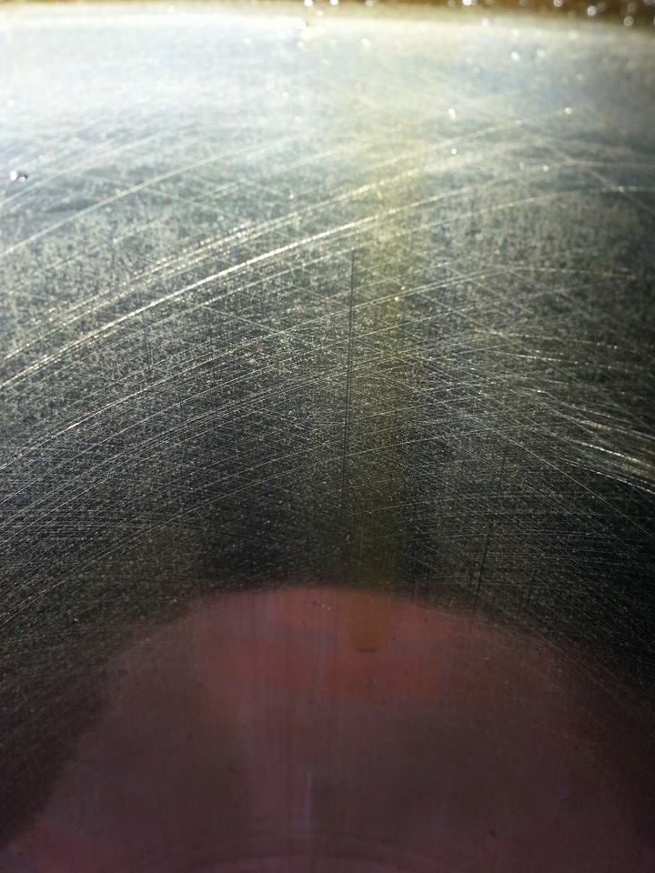 Scratched metal surface with Supermotors.net logo in the lower right corner