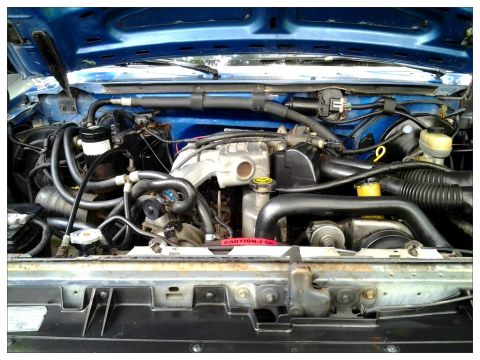 1990 Ford Bronco - Close-up view of the engine compartment, showing intricate mechanical details and wiring.