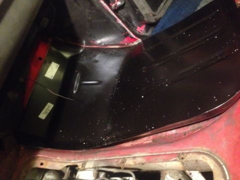1978 Ford Bronco - The interior cargo area shows a black floor mat and red trim, with some labels visible on the side panel.