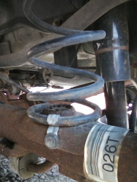1999 Mercury Grand Marquis - The rear suspension system of a vehicle, showing the coil spring and shock absorber assembly.