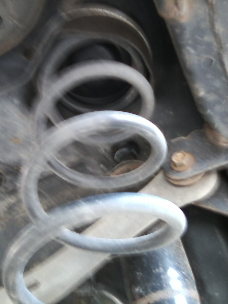 Close-up of a blurry suspension spring and metal components