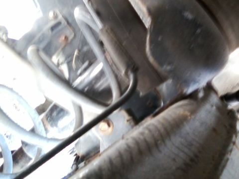 1999 Mercury Grand Marquis - Close-up view of the underbody suspension system, showing various hoses and bolted components.