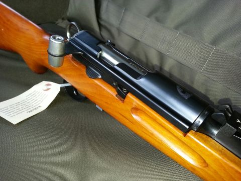 2003 Ford Crown Victoria - Close-up view of a rifle's wooden stock and metal receiver, with a warning tag visible.
