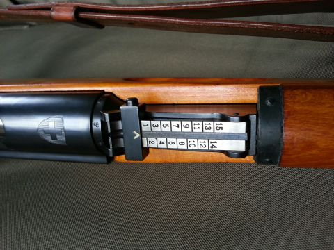 2003 Ford Crown Victoria - A detailed view of a rifle's adjustable sight mechanism, displaying numerical settings for elevation.