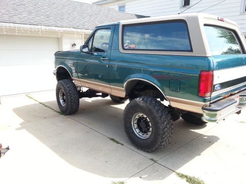1996 Ford Bronco - This lifted 1996 Ford Bronco is shown from the rear quarter angle, large off-road tires.