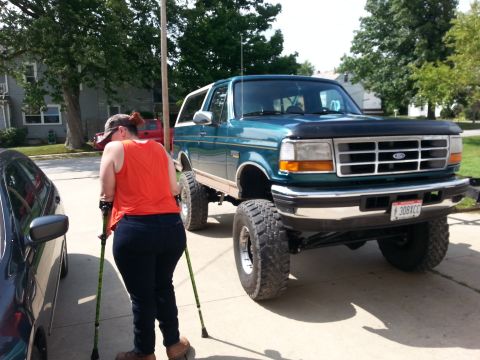 1996 Ford Bronco - This lifted 1996 Ford Bronco features a prominent grille and a custom stance, captured from a three-quarter front perspective.