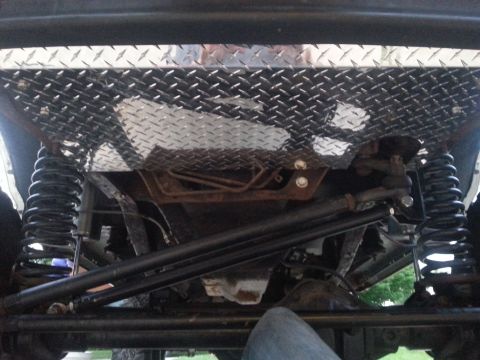 1996 Ford Bronco - Underside view of a vehicle's diamond plate skid plate and suspension system.