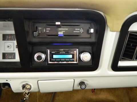 1979 Ford Bronco - Close-up of the dashboard showing the climate control panel and aftermarket radio.