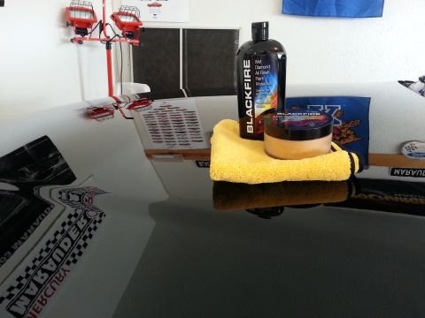 2003 Mercury Marauder - Car detailing products are placed on the hood of a car, ready for use.
