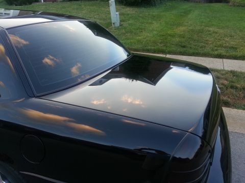 2003 Mercury Marauder - The rear quarter of a black 2003 Mercury Marauder is shown, reflecting the sky and clouds.