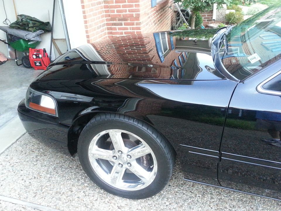 Front fender, wheel, and door of a black 2003 Mercury Marauder