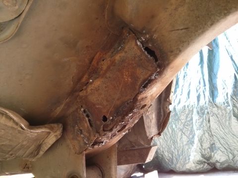 1986 Ford Bronco - Close-up of severe rust damage and repairs on a vehicle frame.