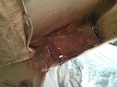 1986 Ford Bronco - Close-up view of heavily rusted and damaged vehicle frame components.