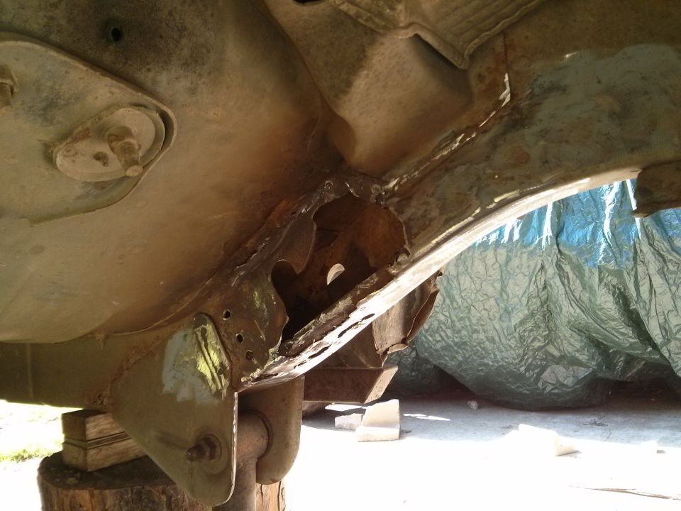 Heavily rusted frame section of a vehicle, possibly a Ford Bronco, showing significant corrosion and damage
