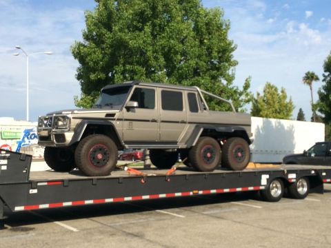 1968 Ford Mustang - A Mercedes-Benz G63 AMG 6x6 is transported on a flatbed trailer.