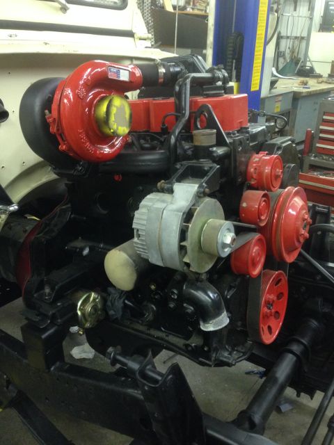 1986 Jeep Wagoneer - A close-up view of a diesel engine, a prominent red turbocharger and accessory drive system.