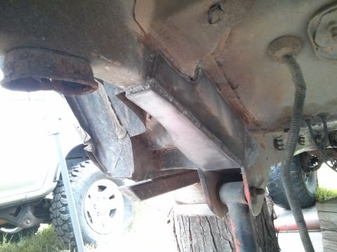 1986 Ford Bronco - The underside of a vehicle shows significant rust on its frame and suspension parts.
