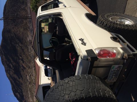 1995 Ford Bronco - This white 1995 Ford Bronco features a removable soft top and aggressive off-road tires, ready for adventure.